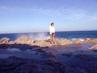 Andie on the wave covered rocks in Cabo San Lucas